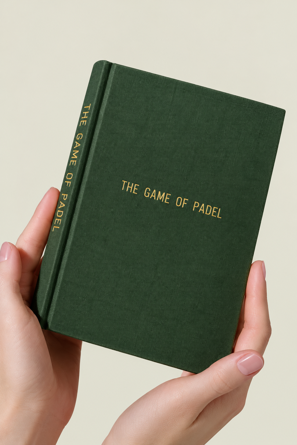 Hands holding The Game of Padel, a green hardback pocket guide for beginners and a padel gift | The Hud