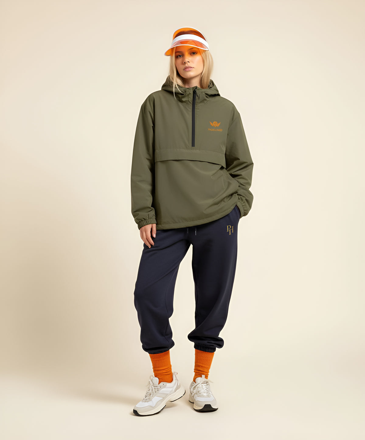 Woman wearing The Woodie Rally Shell, a khaki waterproof padel jacket | The Hud