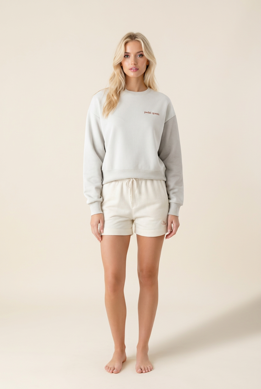 Woman wearing The Padel Queen Sweat, a cream organic cotton sweatshirt, with shorts | The Hud